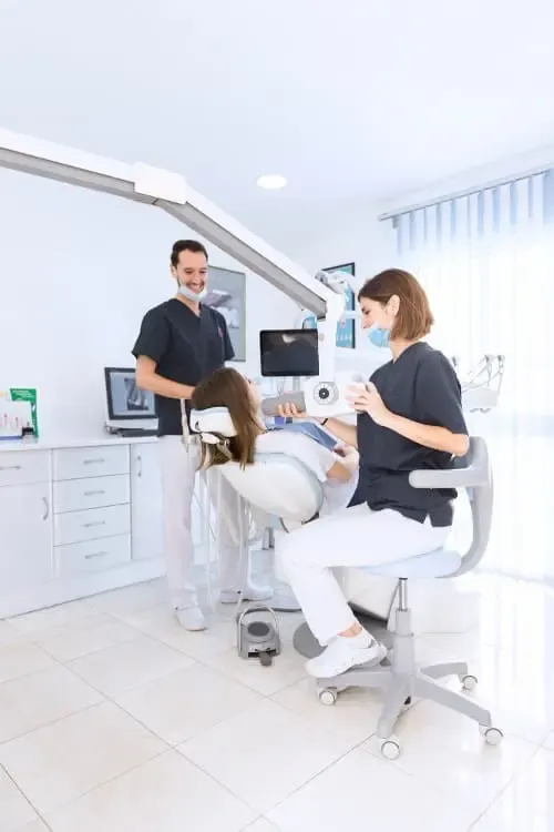 Dentiste et assistante soignant une patiente dans un cabinet dentaire moderne
