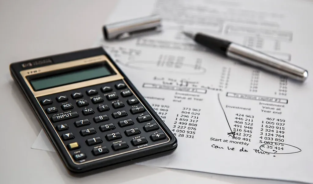 Calculatrice et stylo posés sur un relevé de comptes