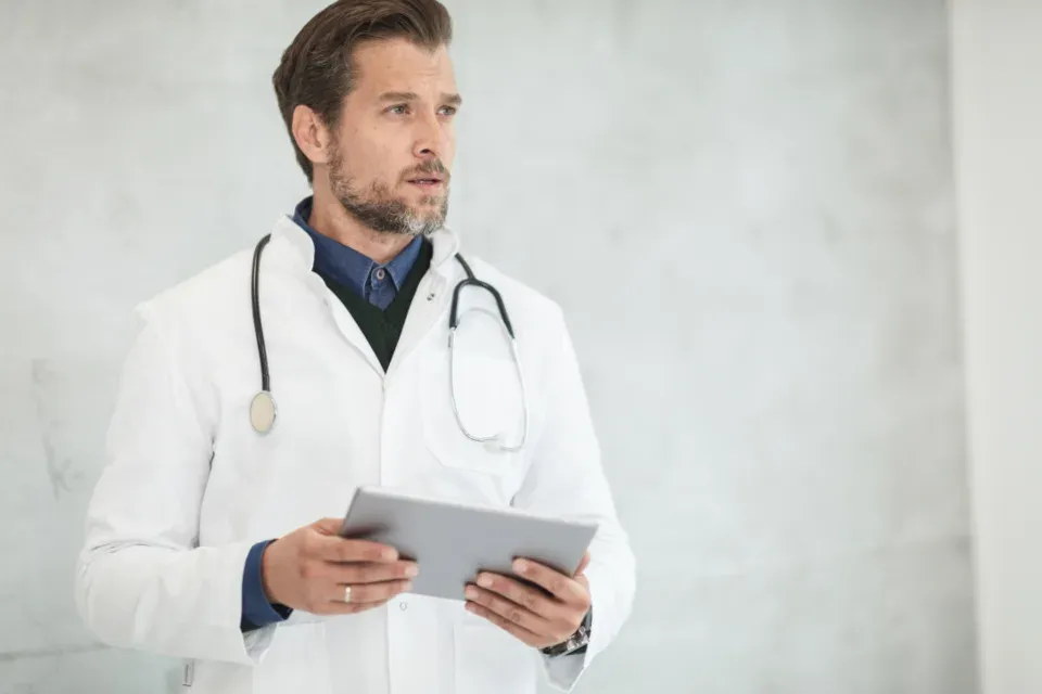 Médecin en blouse blanche tenant une tablette