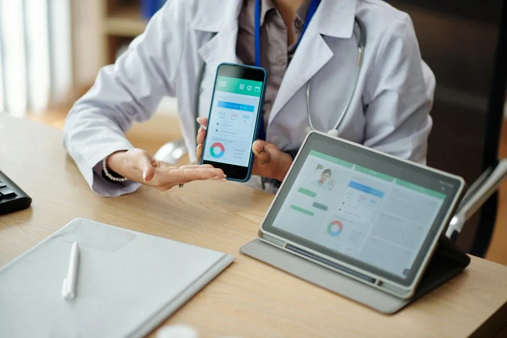 Médecin présentant une application mobile et son tableau de bord sur tablette