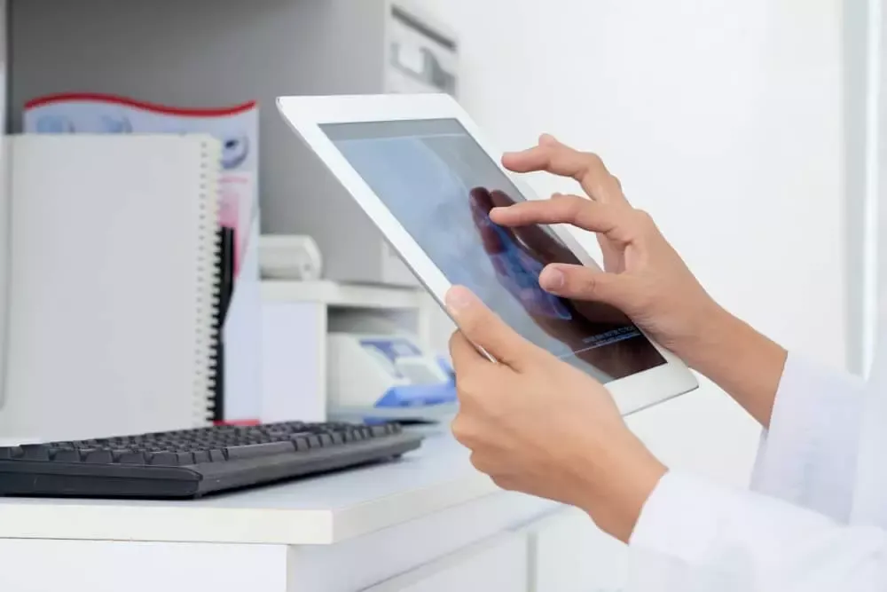 Personne utilisant une tablette tactile sur un bureau