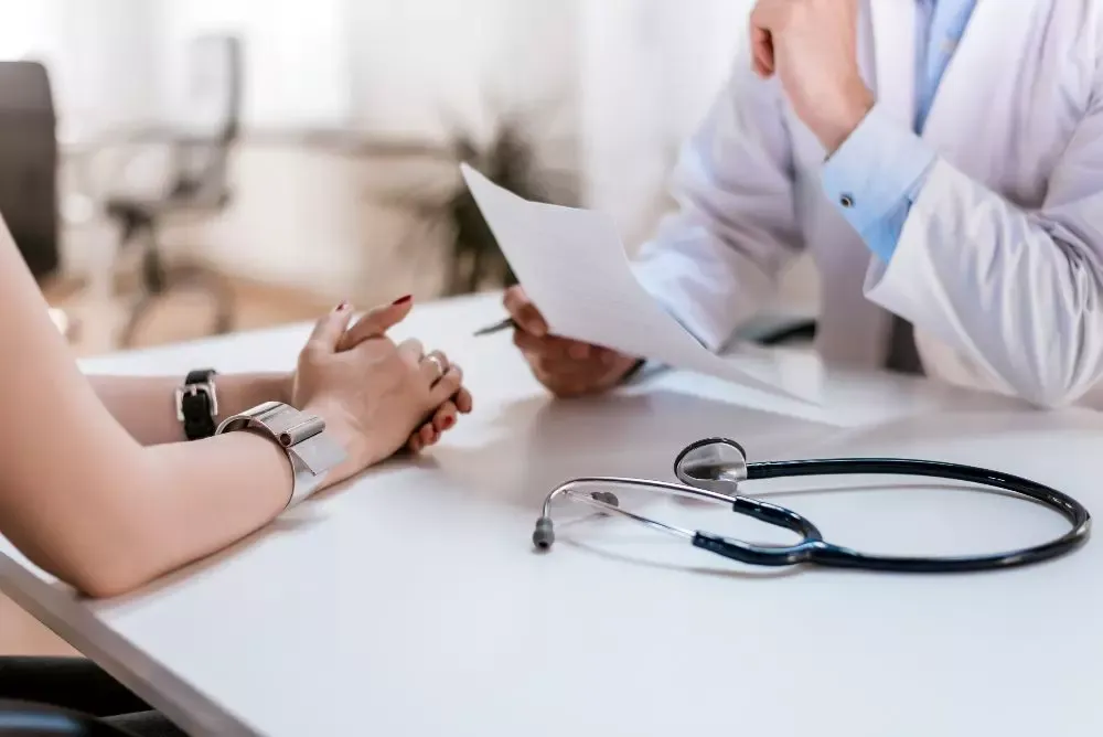 Médecin en consultation, échange avec une patiente au cabinet