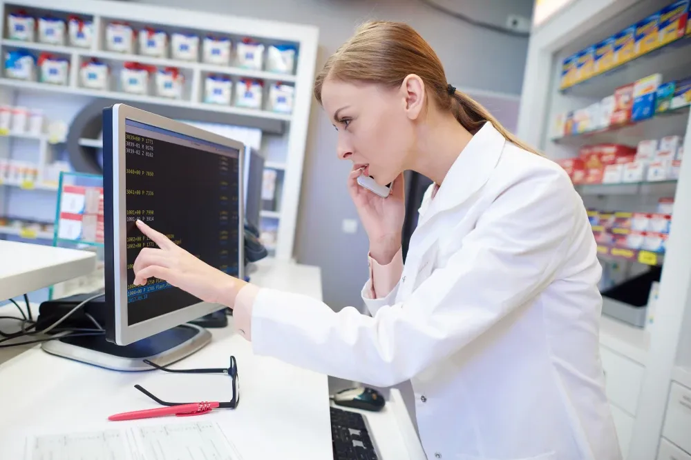 Pharmacienne consultant un écran d’ordinateur dans son officine